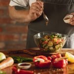 As mãos do chef cortando vegetais em sua cozinha