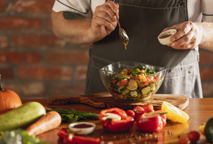 As mãos do chef cortando vegetais em sua cozinha